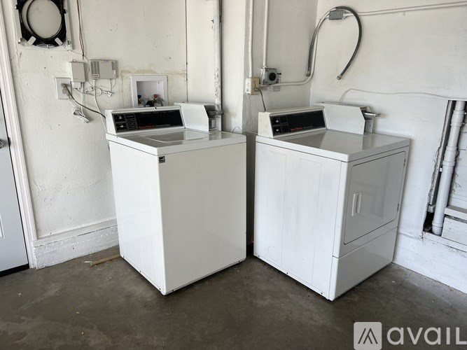 Two white ovens in a room with white walls.