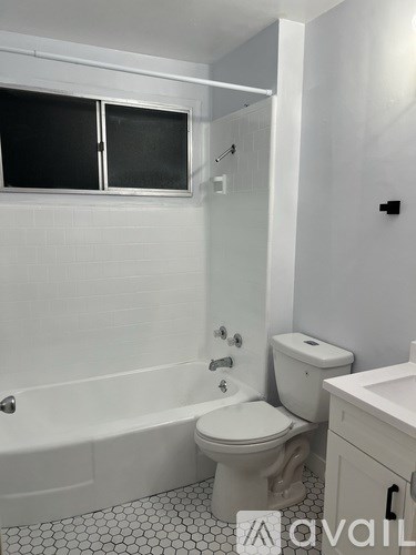 A white bathroom with a toilet, sink, and bathtub.