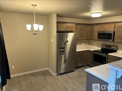A kitchen with a refrigerator, oven, and microwave.