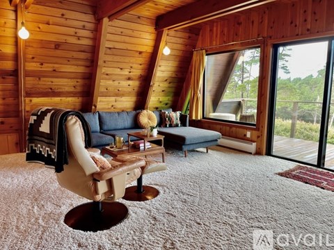 A cozy living room with a blue couch and a chair.