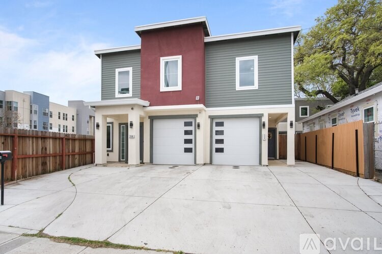 A two-story house with a red and grey exterior and a white garage door.