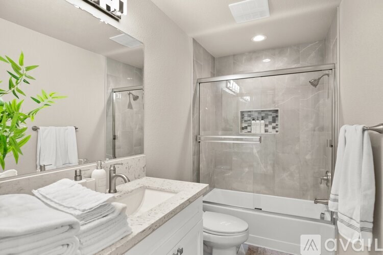 A bathroom with a white toilet, sink, and bathtub.