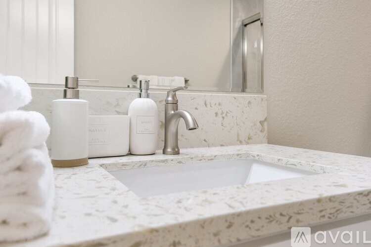 A bathroom sink with a white countertop and a silver faucet.