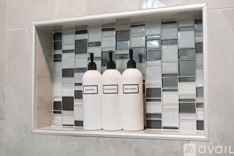 Three bottles of soap are displayed in a white container.