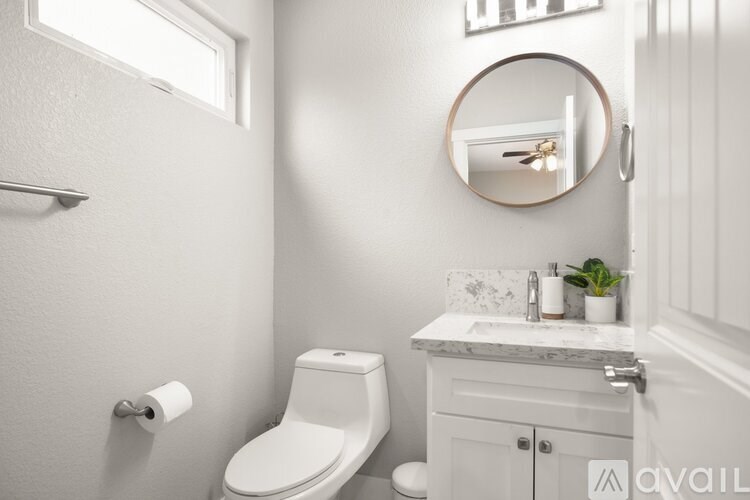 A white toilet sits next to a white sink in a bathroom.