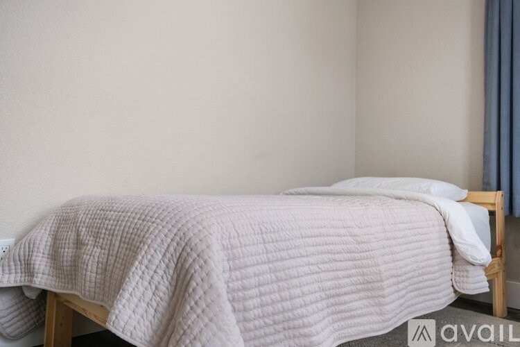 A bed with a white blanket and pillow is in the image.