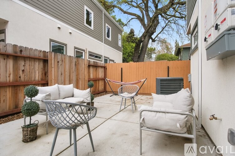 A patio with a white chair and a black table.