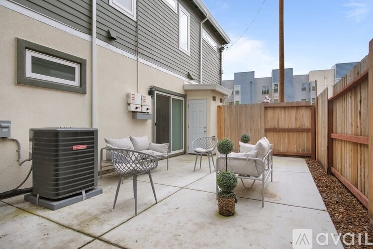 A patio with a table and chairs and a wall-mounted air conditioner unit.
