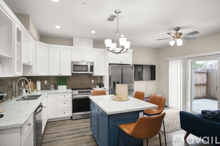 A modern kitchen with a blue island and white cabinets.