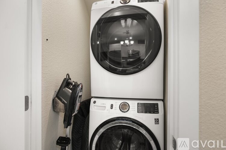 A stack of a washing machine and dryer in a small room.