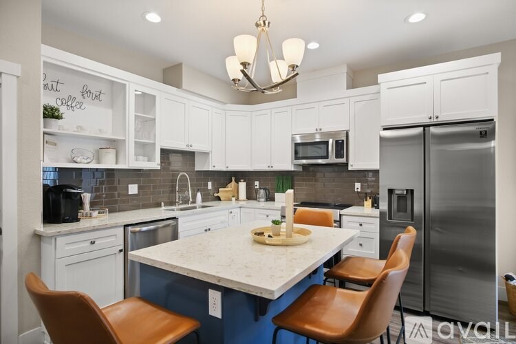A kitchen with a table and chairs in front of a refrigerator.