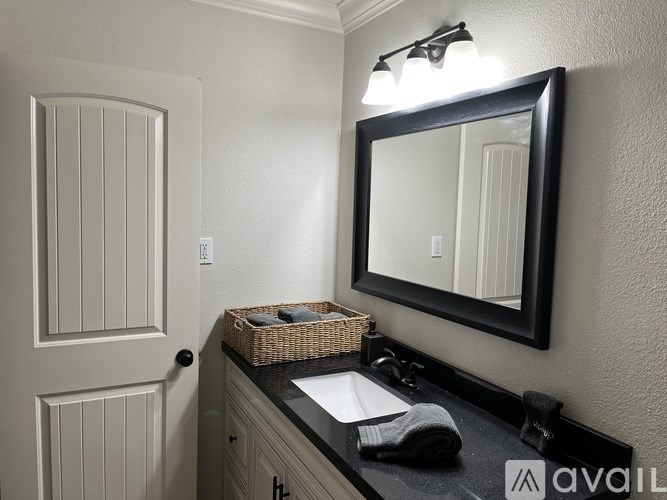 A bathroom with a sink, mirror, and light switch.