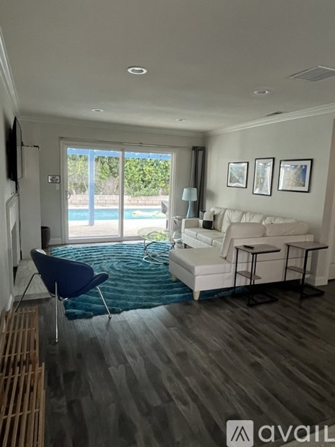 A living room with a blue chair and a white couch.