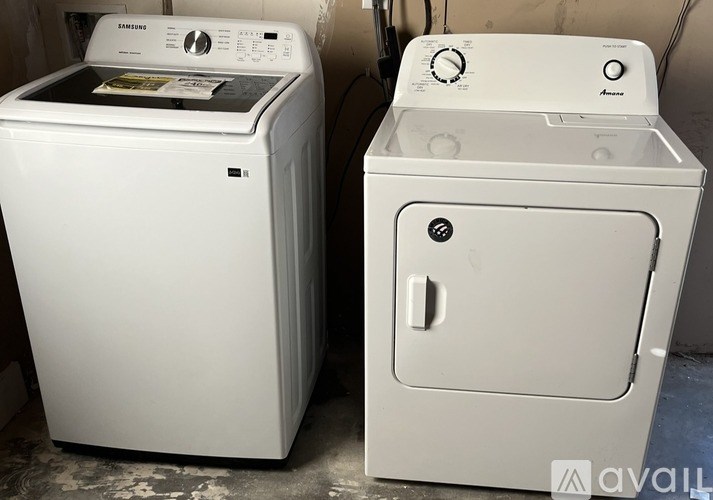 Two white front loading washing machines are placed next to each other.