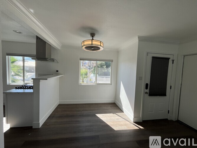 A bedroom with a bed, dressers, and a television.