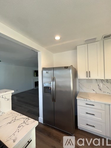 A bathroom with a sink, mirror, and shower.