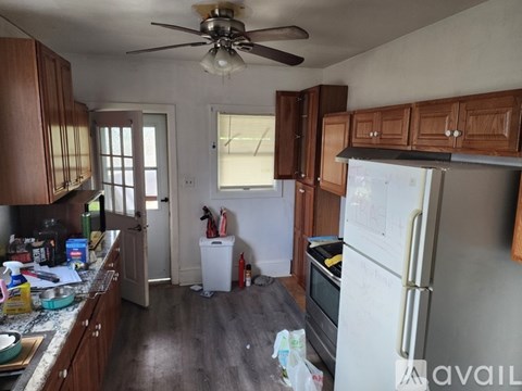 A kitchen with wooden cabinets and a white refrigerator.