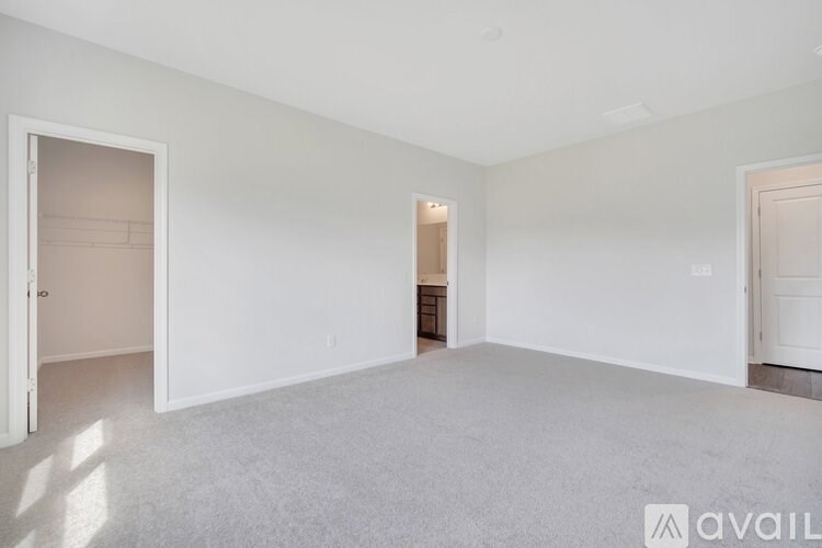 A spacious empty room with a door on the left and another door on the right.
