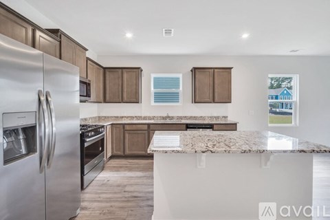 A modern kitchen with a stainless steel refrigerator and wooden cabinets.