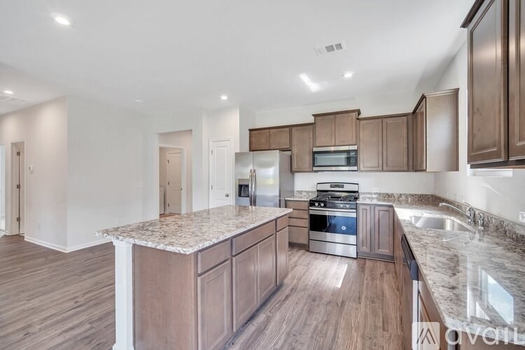 A kitchen with wooden cabinets and a granite countertop.
