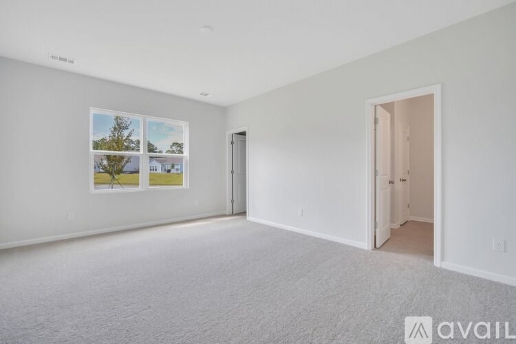 A room with a white carpet and a picture on the wall.