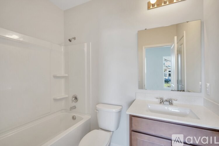 A bathroom with a toilet, sink, and bathtub.