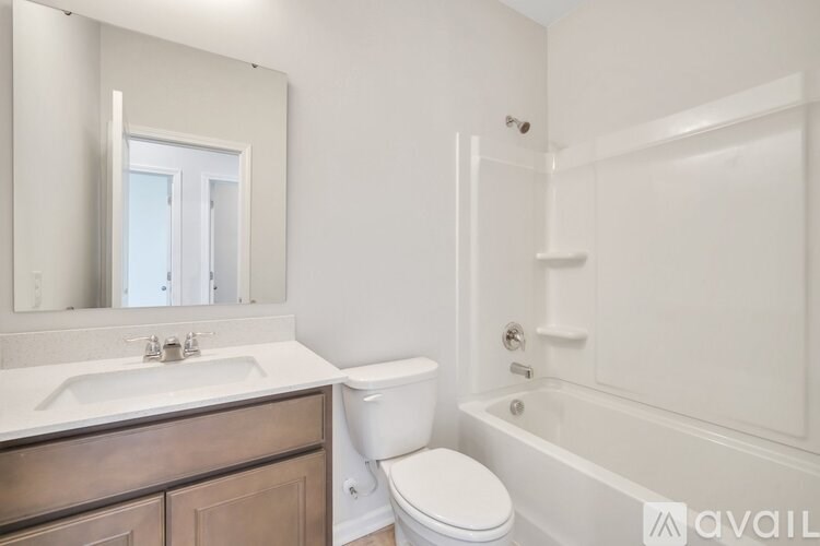 A white bathroom with a toilet, sink, and bathtub.