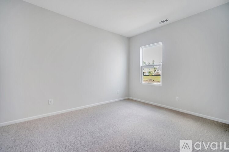 A white room with a window and a picture on the wall.