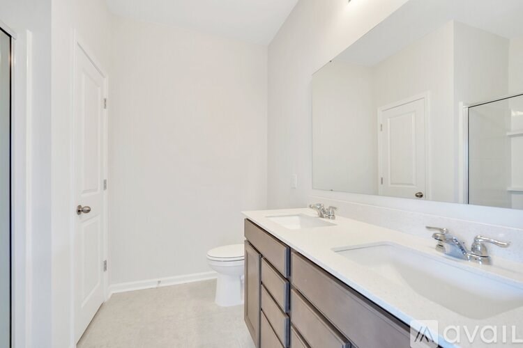 A bathroom with a toilet, sink, and mirror.