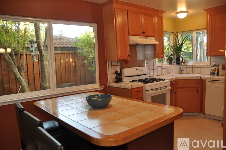 A kitchen with wooden cabinets and a white stove top oven.