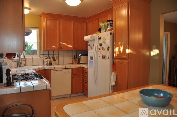 A kitchen with a white fridge and wooden cabinets.