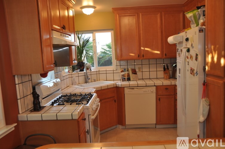 A kitchen with wooden cabinets and a white fridge.