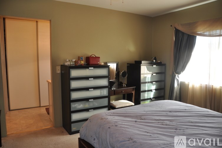 A bedroom with a bed, a dresser, and a wardrobe.