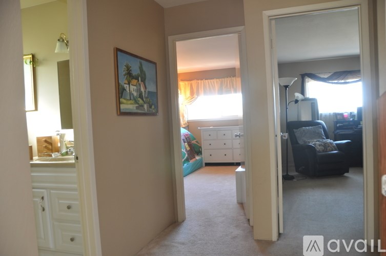 A living room with a painting on the wall and a couch.