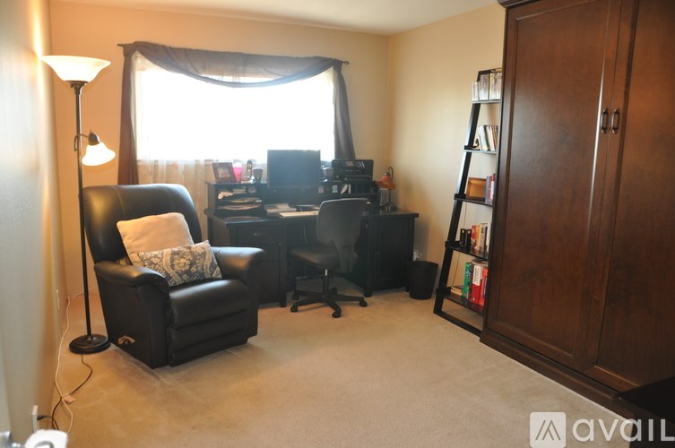 A living room with a black leather chair and a television.