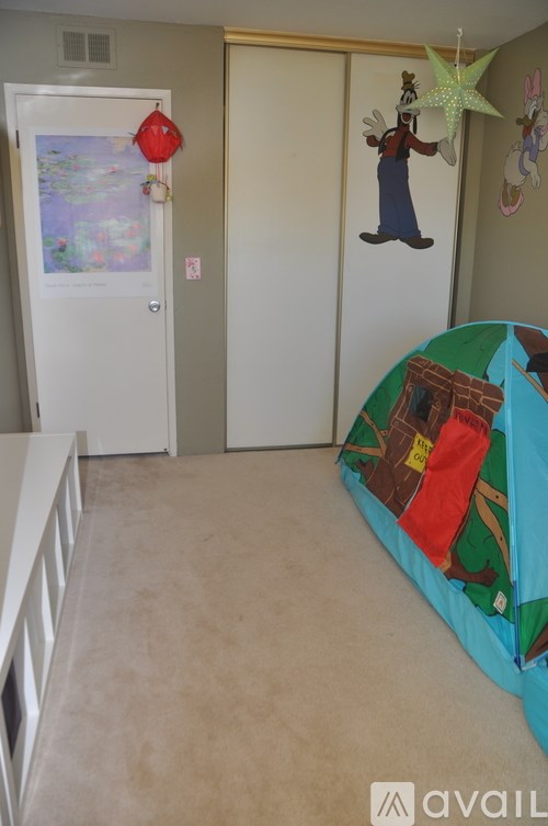 A room with a blue bed and a map on the wall.