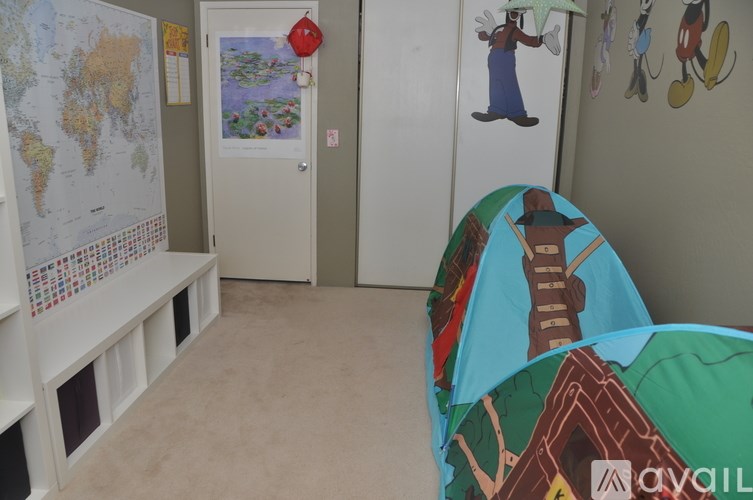 A child's room with a world map on the wall and a bed with a cowboy print.