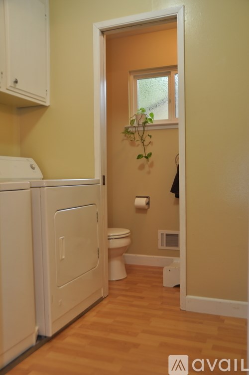 A small bathroom with a toilet, sink, and a window.