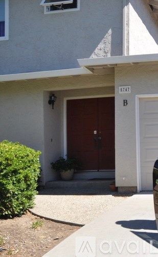 A house numbered 9247 with a brown door and a white door.