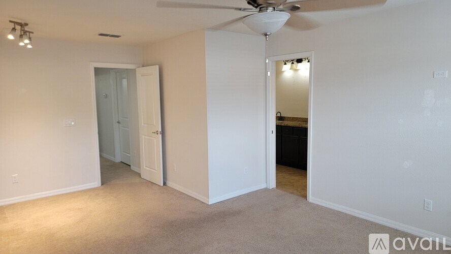 A room with a fan and two doors.