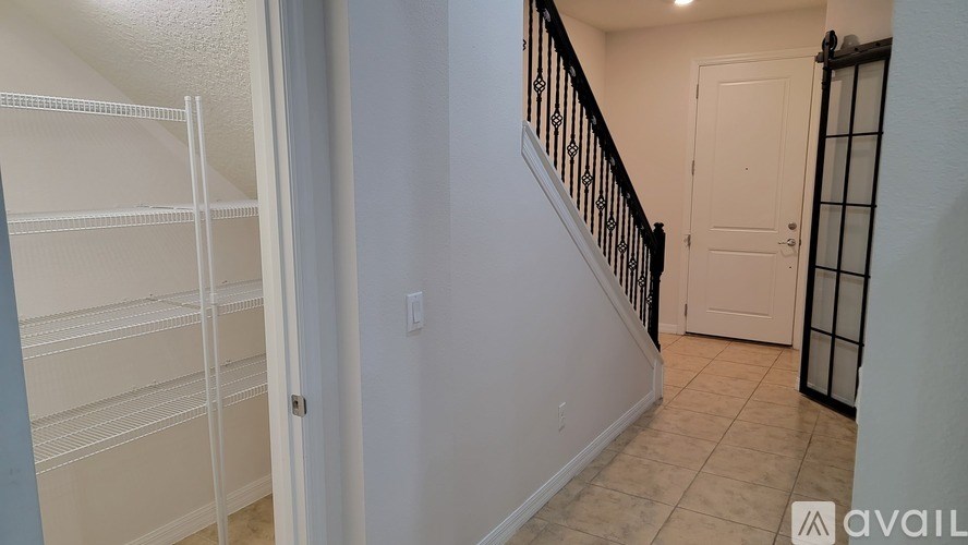 A hallway with a staircase and a door.