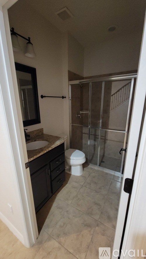 A bathroom with a toilet, sink, and shower.