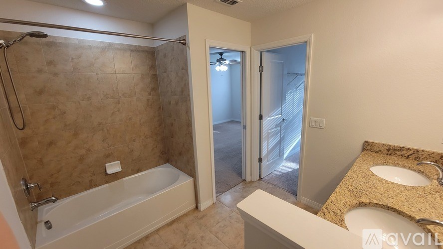 A bathroom with a tub, sink, and shower.