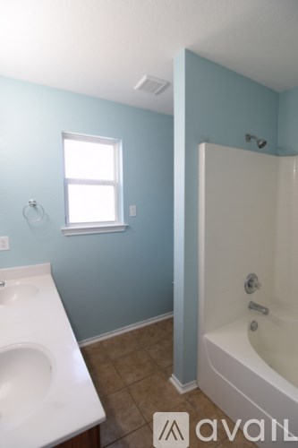 A bathroom with a white sink and bathtub.