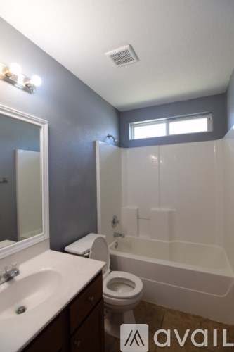 A bathroom with a toilet, sink, and bathtub.