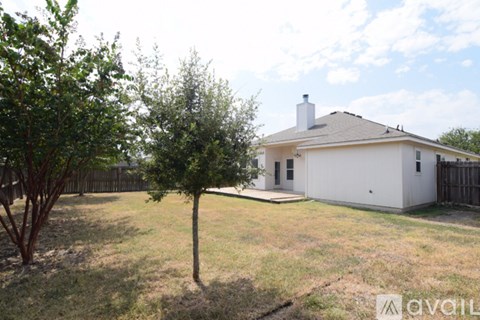 A white house with a tree in front of it.