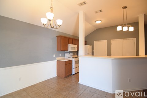 A kitchen with white appliances and brown cabinets.