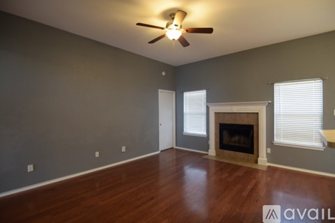 A room with a fireplace and a ceiling fan.