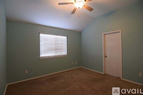 A room with a ceiling fan and a window with blinds.