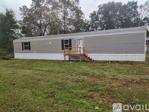 A mobile home with a deck and a small porch.